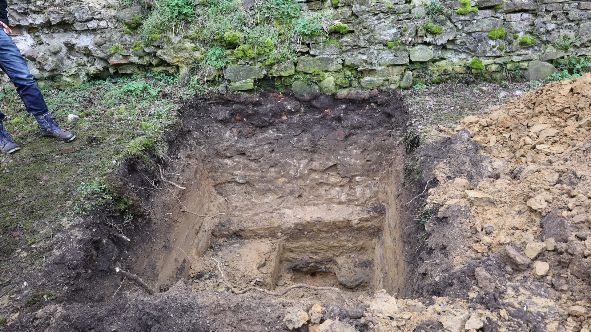 Wykop archeologiczny z odsłoniętym fragmentem fundamentowej części murów obronnych zamku w Dankowie.